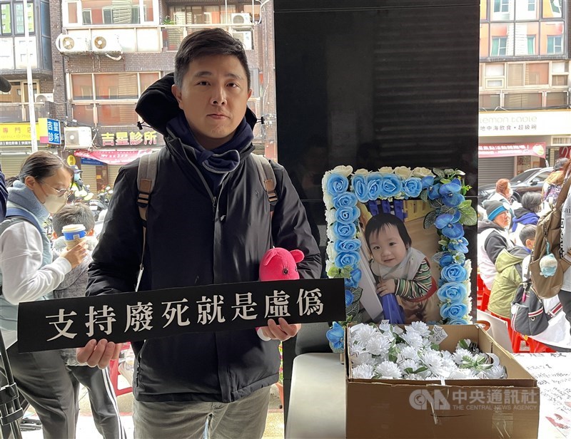 Jeffrey Hsieh holds a placard reading “Support for abolishing the death penalty is hypocrisy” next to a framed photo of Kai Kai at a march in Taipei on Sunday. CNA photo Jan. 11, 2026
