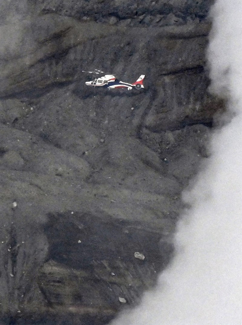 A rescue helicopter hovers in the Mount Aso area in search of a missing sightseeing helicopter. Photo: Kyodo News