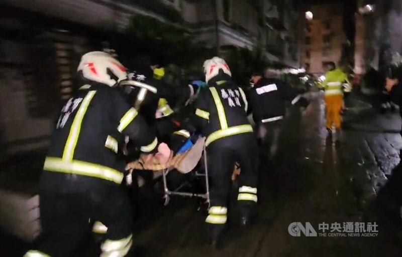 Rescue workers rush firefighter Chan Neng-chieh, who gave his breathing mask to a woman trapped in a burning residential building, to hospital early Thursday after he lost consciousness and was pulled from the house. CNA photo Jan. 22, 2026