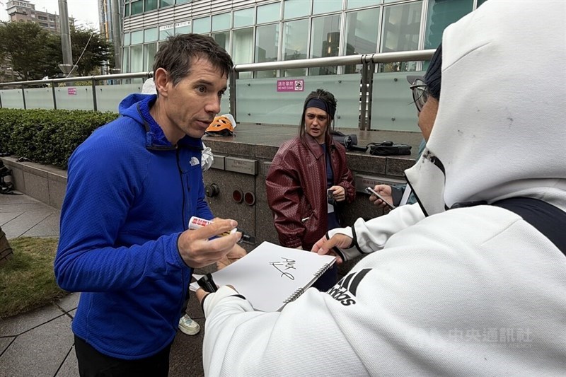 American climber Alex Honnold signs an autograph for a fan outside of Taipei 101 on Wednesday. CNA photo Jan. 21, 2026