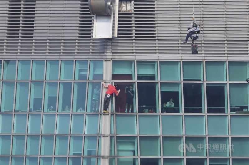 American climber Alex Honnold (in red) attempts a ropeless solo ascent of Taipei 101 on Sunday, waving to people inside the building as he climbs. CNA photo Jan. 25, 2026