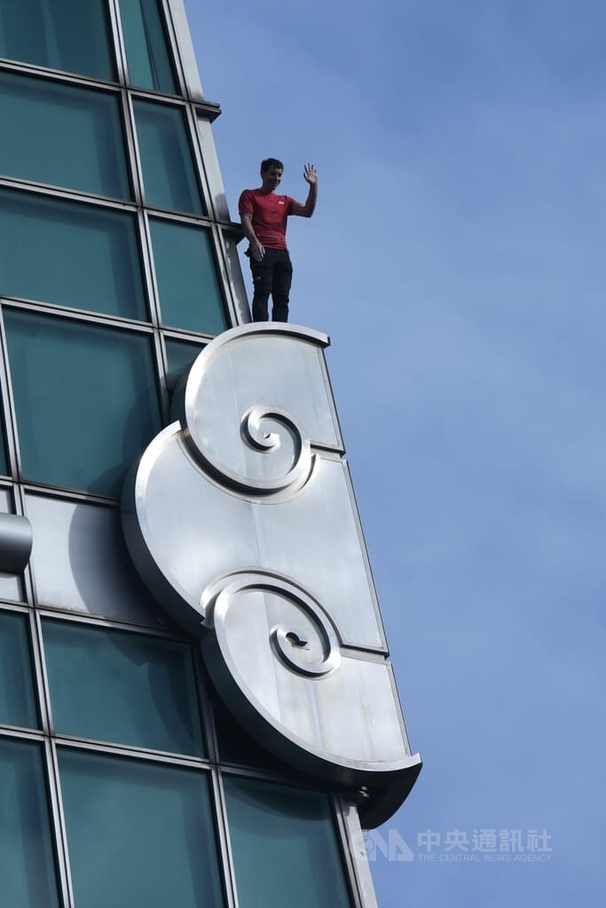 American climber Alex Honnold scales Taipei 101 without ropes on Sunday and waves to fans waiting below as he reaches the first exterior cloud-shaped ornament. CNA photo Jan. 25, 2026