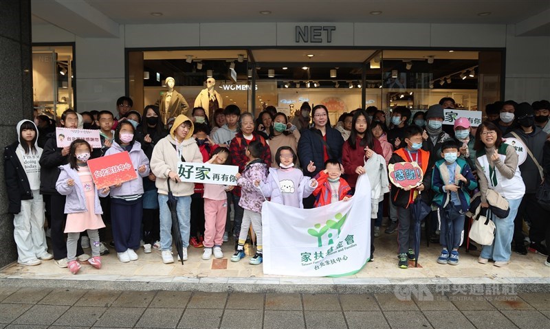 Children and parents taking part in NET’s closed-store shopping session pose for a group photo outside the brand’s flagship store in Taipei in late January. CNA photo Feb. 14, 2026