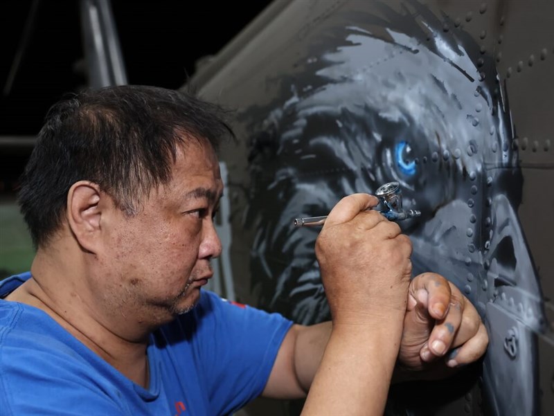 Fan Cheng-pin touches up the hawk emblem on an Army helicopter using an airbrush. Photo courtesy of Fu Hsin-ming