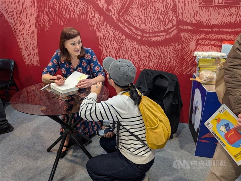 Czech author Kateřina Tučková signs a Chinese-language edition of "The Last Goddess" and interacts with a reader at the Taipei International Book Exhibition in early February. CNA photo Feb. 22, 2026