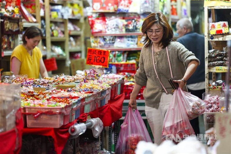 A woman walks out of a food store in Taipei’s Zhongshan District. CNA file photo