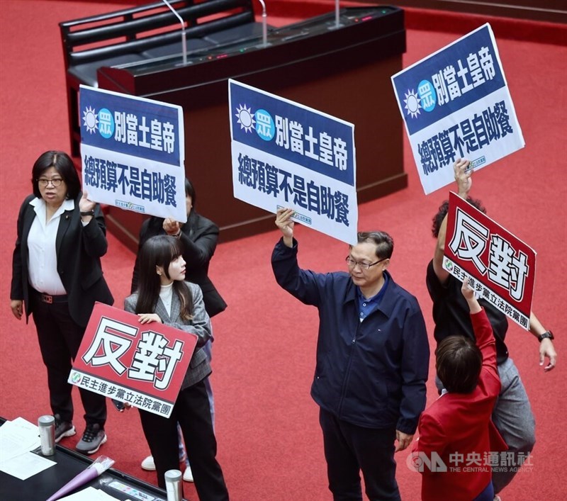 Democratic Progressive Party lawmakers on Friday hold slogans at the Legislature calling for KMT and TPP lawmakers to stop selectively handling budget bills. CNA photo March 6, 2026