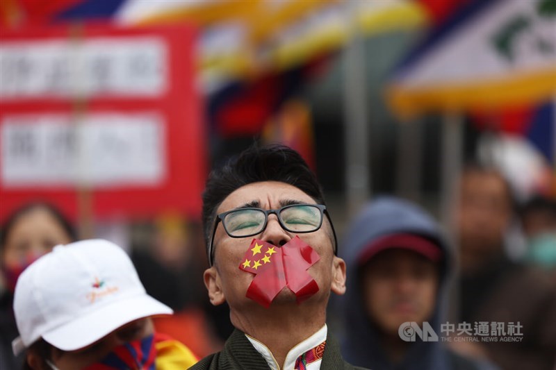 Taiwan-based Tibetan and secretary-general of the Human Rights Network for Tibet and Taiwan Tashi Tsering marches on Saturday with his mouth sealed by tape bearing the design of the Chinese flag. CNA photo March 7, 2026