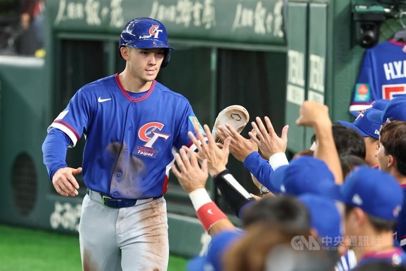 Taiwan's Stuart Fairchild (left) high-fives his teammates after smashing a grand slam in the second inning of Saturday's game at the Tokyo Dome. CNA photo March 7, 2026