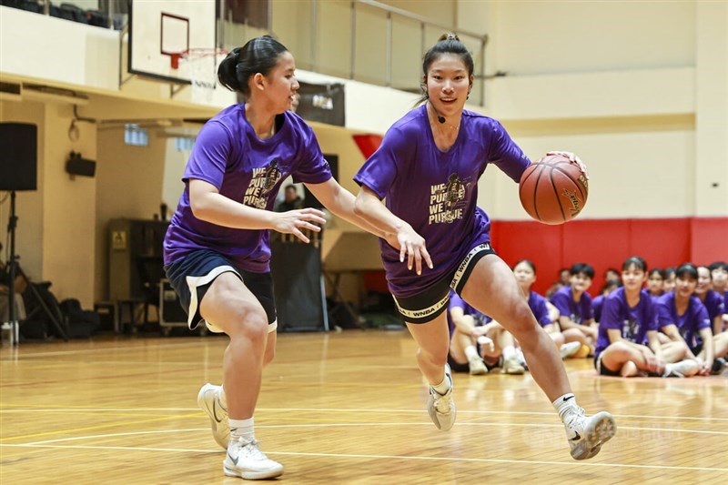 Taiwanese-American WNBA player Kaitlyn Chen (right) plays against a local player during her inaugural basketball camp in Taipei on Tuesday. CNA photo March 10, 2026