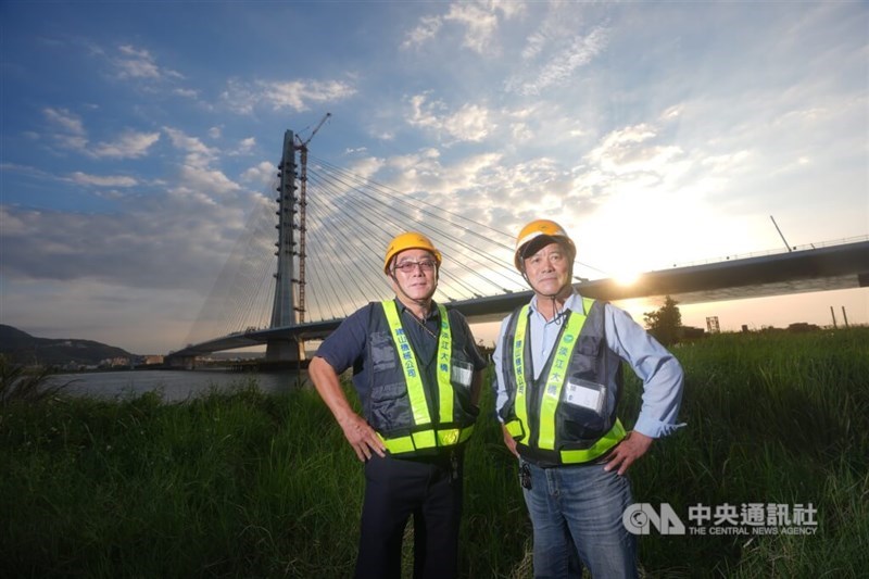 Chang Ching-chune (right) and Chang Ching-chen (left) of Cheng-shine Machinery Co., Ltd. pose in front of Danjiang Bridge at sunset in early October 2025. CNA photo March 11, 2026