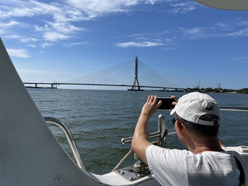 A ferry rider takes a picture of Danjiang Bridge in early October 2025. The ferry is currently the only direct public transport link between New Taipei’s Tamsui and Bali districts, CNA photo March 11, 2026