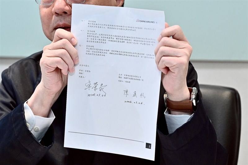 Premier Cho displays a part of his charter flight contract with China Airlines at a press conference in Taipei on Friday. Photo courtesy of the Executive Yuan