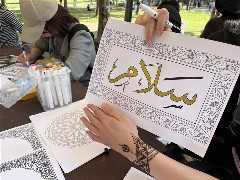 Esther Liao, who declined to have her face photographed, holds up Arabic calligraphy reading “peace” with her henna-painted hand during an Eid al-Fitr celebration in Taipei on Sunday. CNA photo March 22, 2026