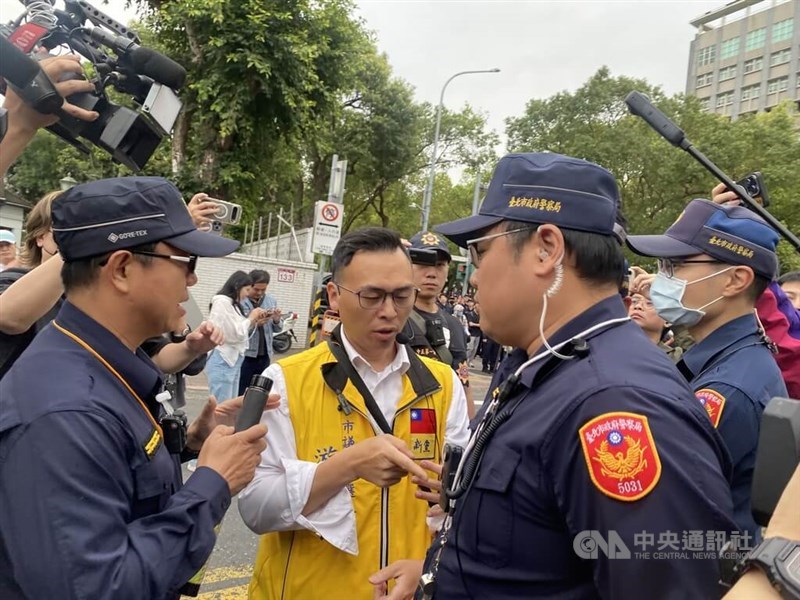 New Party Deputy Secretary-General You Chih-pin (center), who threw water balloons at a display in support of "judicial justice" following former Taipei Mayor Ko Wen-je's verdict, talks with police officers outside Taipei District Court on Thursday. CNA photo March 26, 2026