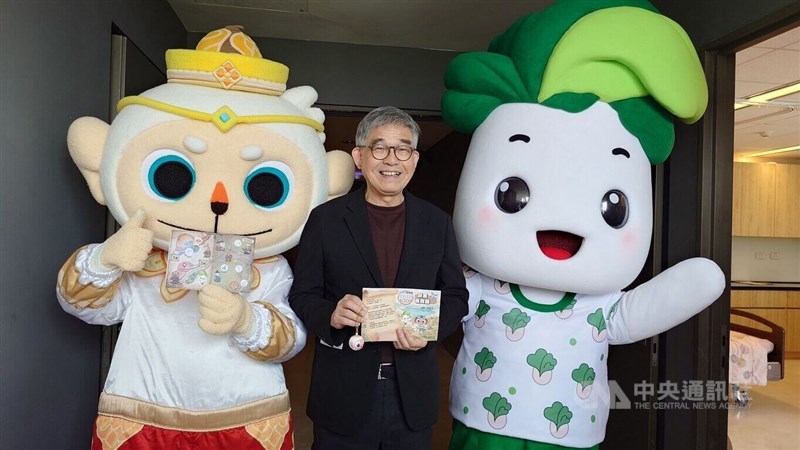 Mascots of the Southern Branch of the National Palace Museum wave as Huang Yung-tai (center), the museum’s deputy director of administrative affairs, showcases a keychain designed as a gift for children in Chiayi County on Thursday. CNA photo April 2, 2026