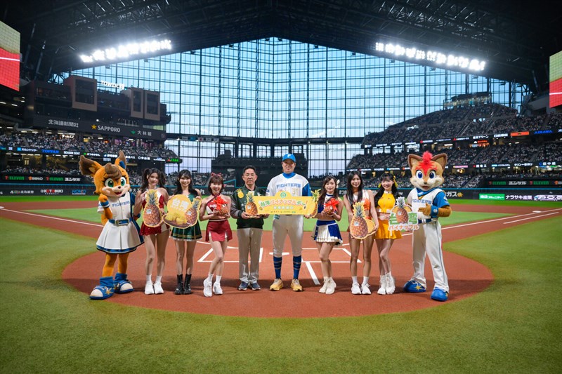 Nippon-Ham Fighters Taiwanese player Gu Lin Ruei-yang (fifth right) and Taiwan's Agriculture and Food Agency Chief Secretary Chen Li-yi (fifth left) pose together with Taiwan's famous baseball cheerleaders inside Es Con Field Hokkaido stadium on Friday to promote the "Taiwan Pineapple Day." Photo courtesy of the Ministry of Agriculture