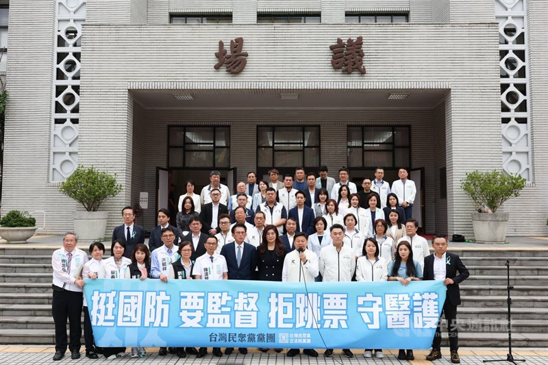 KMT and TPP lawmakers hold a banner while explaining the details of the newly passed defense budget bill at the Legislative Yuan on Friday. CNA photo May 8, 2026