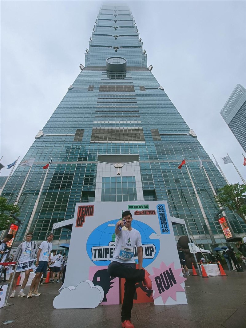 John, an amateur participant, poses in front of Taipei 101 after the race. Photo courtesy of a private contributor.