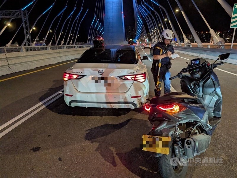 A New Taipei police officer responds to a motorcycle-car collision on the Danjiang Bridge on Tuesday night. CNA photo May 13, 2026