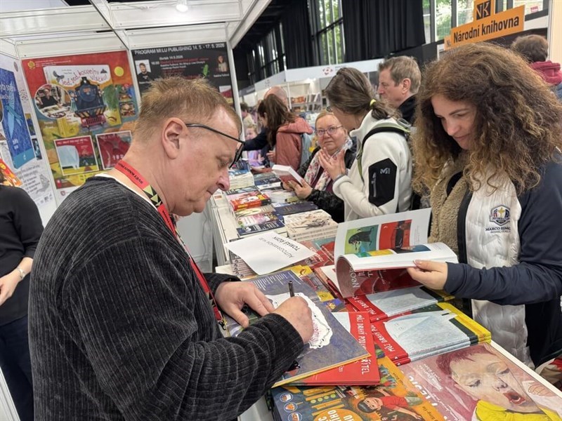 Tomáš Řízek (left) signs a book for his reader at the Book World Prague fair in Prague on Saturday. CNA photo May 19, 2026