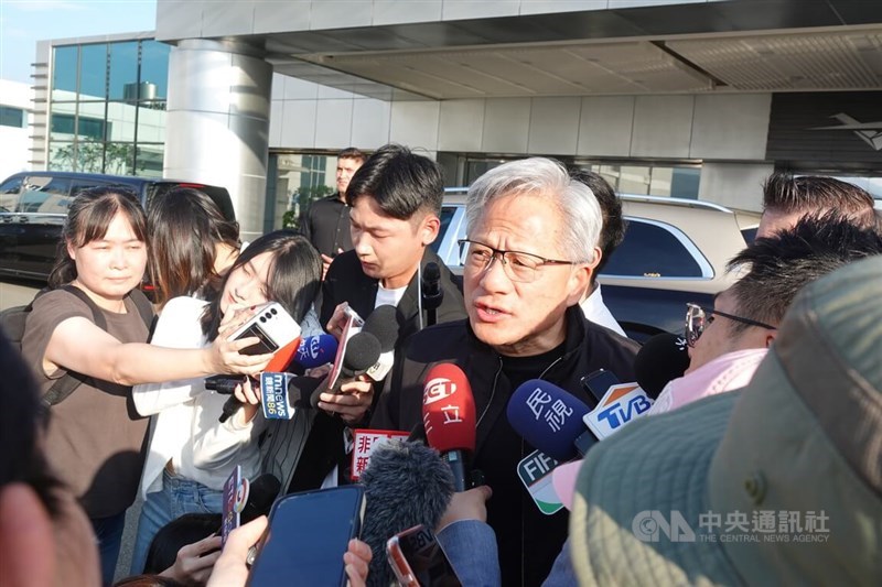 Nvidia Corp. CEO Jensen Huang (center right) speaks to the media after arriving at Taipei's Songshan Airport on Saturday. CNA photo May 23, 2026