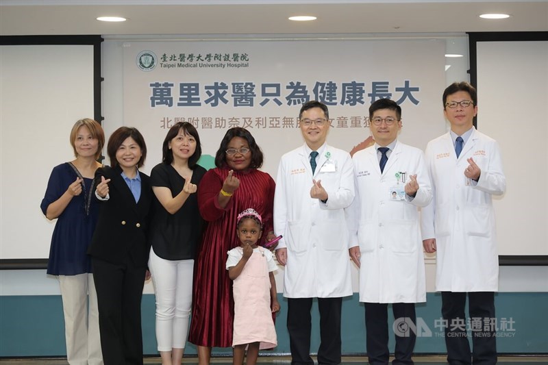TMUH President Shih Chun-ming (third right), TMUH Director of Pediatric Surgery Huang Fu-huan (second right), Nigerian girl Miracle (front center), and her mother Jennifer (fourth left) pose for a photo at a press conference at Taipei Medical University Hospital in Taipei on Monday. CNA photo June 23, 2026