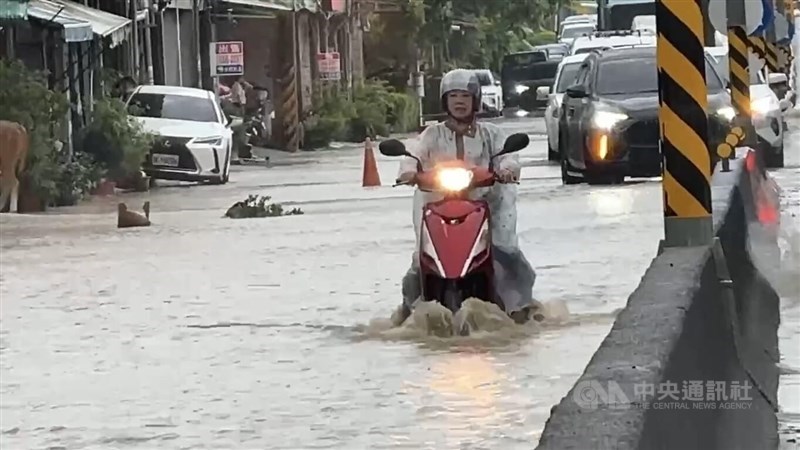A scooter rider splashes through a flooded street in Qishan District, Kaohsiung, on Thursday. CNA photo June 25, 2026