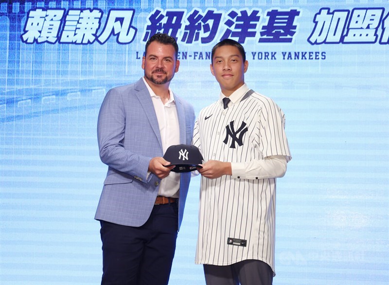 Yankees director of international scouting Mario Garza (left) presents a New York Yankees cap to Taiwanese pitcher Lai Chien-fan (right) at a signing ceremony in Taipei on Friday. CNA photo June 26, 2026