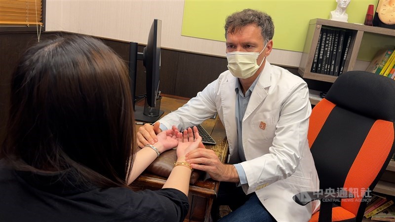 Marcin Zbylut checks the pulse of a patient during a consultation at a clinic in New Taipei in mid-April. CNA photo June 29, 2026