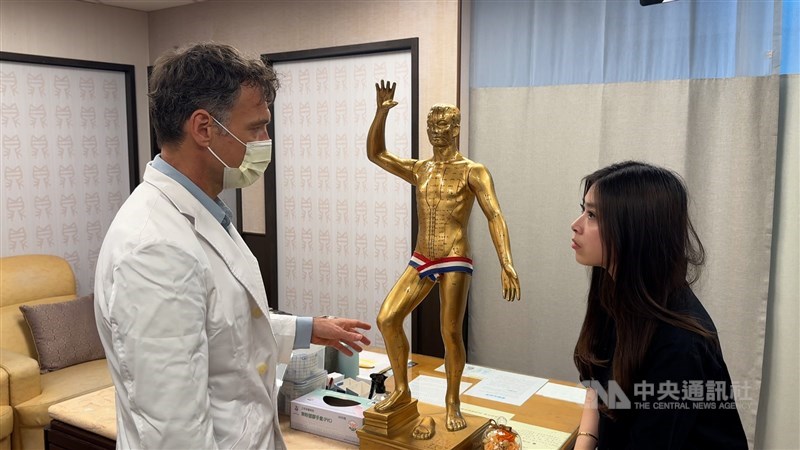 Marcin Zbylut explains the principles of traditional Chinese medicine to a patient at a clinic in New Taipei in mid-April. CNA photo June 29, 2026