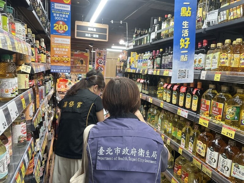 Taipei City Government officials inspect cooking oil products on shelves at a supermarket on Thursday. Photo courtesy of Taipei City Government