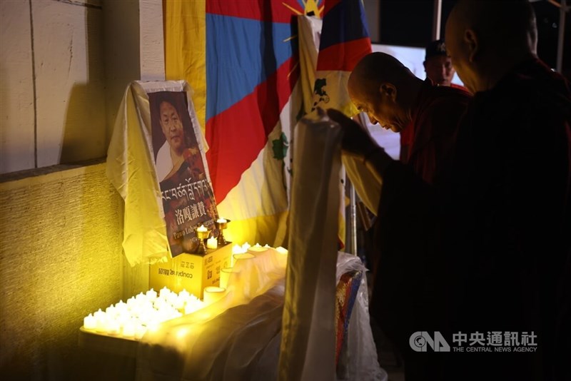 A monk offers a khata before a portrait of Lobga Rangzen during a memorial gathering at Liberty Square in Taipei on Wednesday evening. CNA photo July 15, 2026