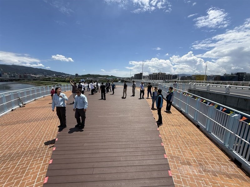 People stand and walk on the viewing platform of the newly opened elevated pedestrian walkway connected to Minquan Bridge in Taipei on Monday. CNA photo July 20, 2026