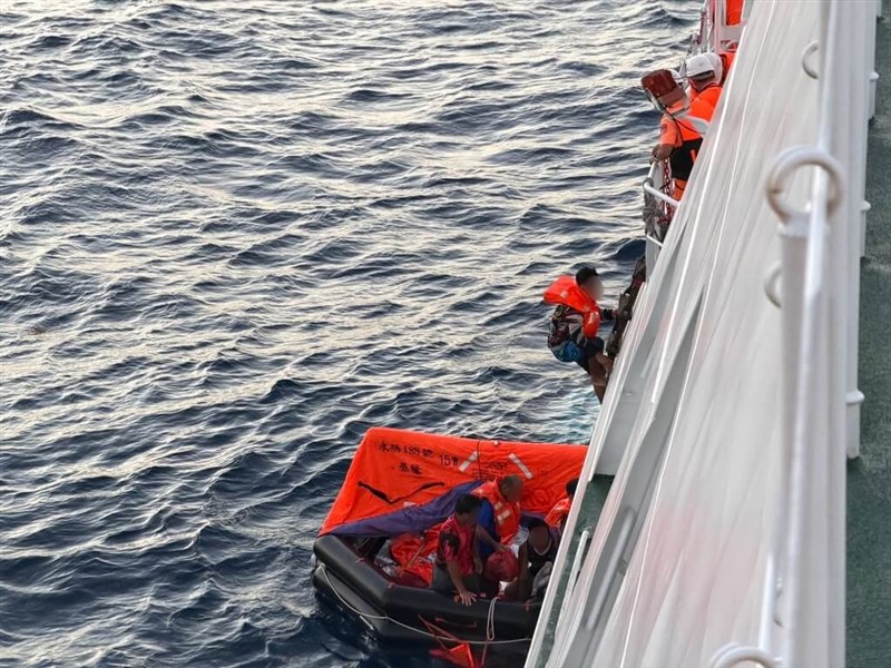 Crew members of the Keelung-registered fishing vessel Yung Fu No. 188 board a Coast Guard Administration patrol vessel in waters northeast of Pengjia Islet on Wednesday. Photo courtesy of Coast Guard Administration