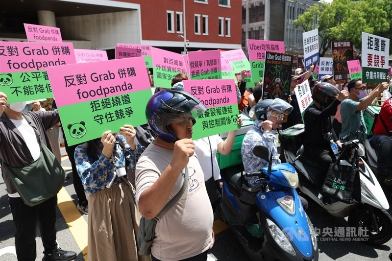 Delivery workers and supporters hold placards during a protest outside the Fair Trade Commission's office in Taipei on Wednesday against Grab's proposed acquisition of foodpanda Taiwan. CNA photo July 22, 2026