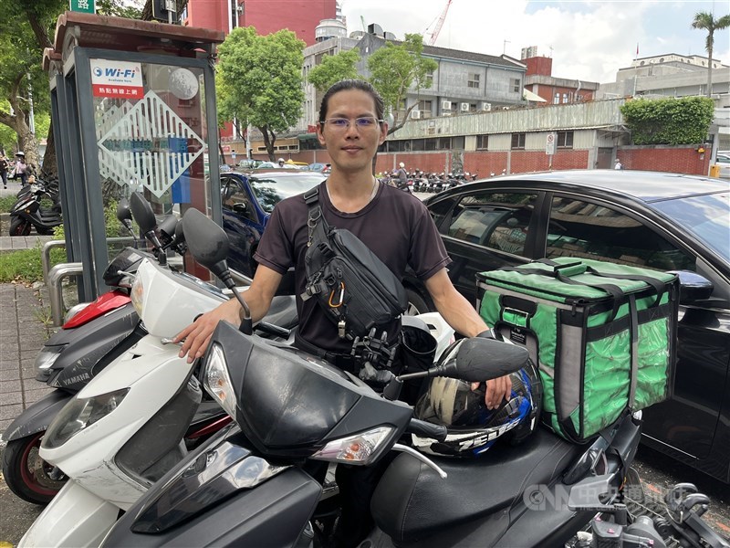 Delivery worker Leo Hsu poses with the motorbike he uses for deliveries after a protest outside the Fair Trade Commission's office in Taipei on Wednesday. CNA photo July 22, 2026