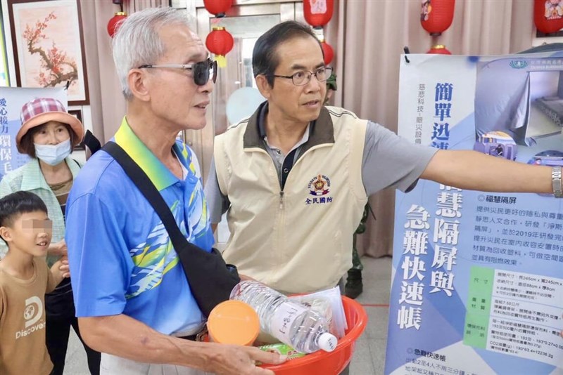 A volunteer distributes daily necessities to a resident at a simulated relief station during the Penghu County Reserve Command's civilian shelter drill as part of the Han Kuang military exercises in Penghu County on Thursday. Photo courtesy of Penghu County Reserve Command