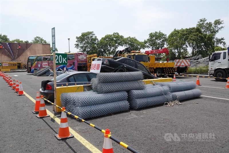 Materials including wire mesh rolls and vehicles for a simulated blocking barrier at Hsuehshan Tunnel are installed Thursday during Han Kuang military exercises in Yilan County. CNA photo Aug. 13, 2026