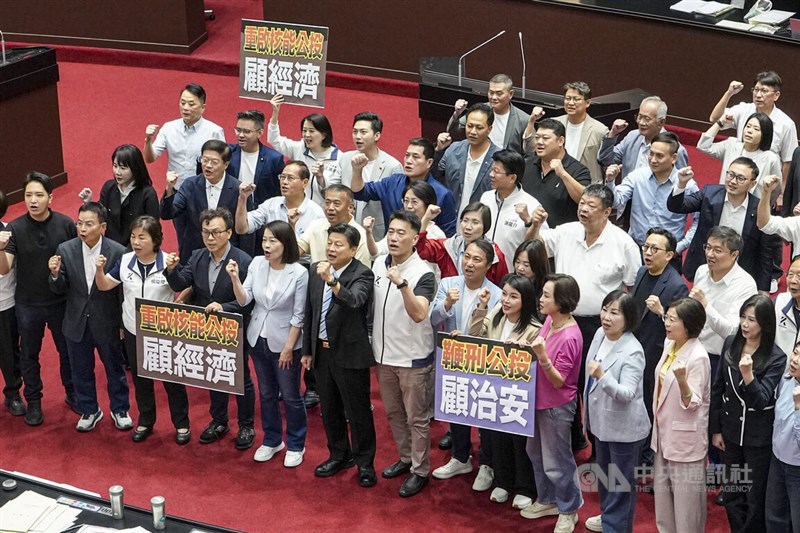 Kuomintang lawmakers hold up signs reading "Restart nuclear energy referendum for economy" and "Caning referendum for security" in the Legislative Yuan chamber in Taipei on Friday as the legislature voted on opposition-backed referendum proposals. CNA photo Aug. 14, 2026