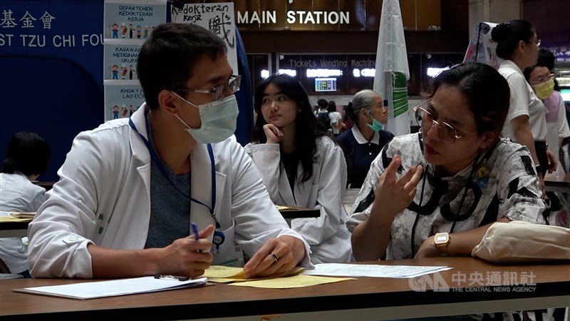 A migrant worker (right) receives a medical consultation from a doctor during a free health check event at Taipei Main Station on Sunday. CNA photo Aug. 16, 2026