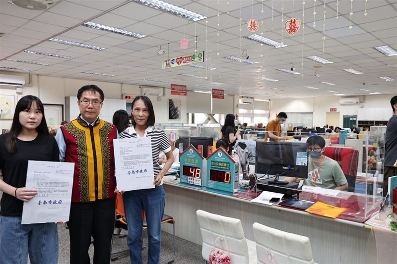 Shih Ya-hsin (left) and her mother Mai Fang-chi (right) hold documents at the South District Household Registration Office in Tainan on Wednesday after completing their official registration as Indigenous Siraya people, accompanied by Tainan Mayor Huang Wei-che (center). Photo courtesy of Tainan City Government