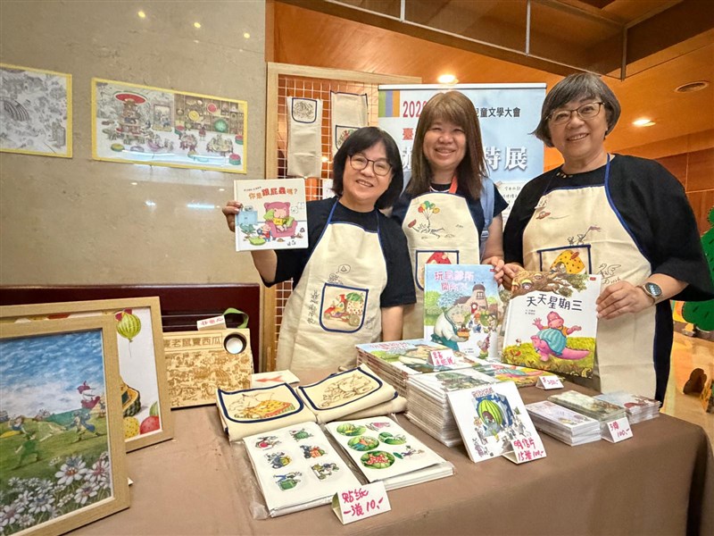 Staffs hold up children's books at a sustainability-themed reading room exhibition organized by the CommonWealth Education Foundation at the 17th Asian Children's Literature Convention 2026 in Tainan. Photo courtesy of Society of Children's Literature, R.O.C.