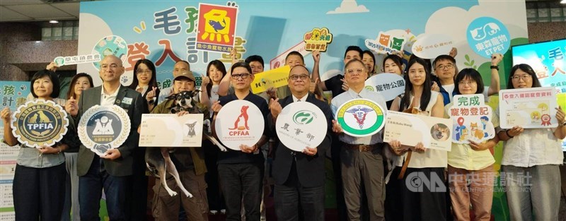 Attendees at a Ministry of Agriculture press conference in Taipei on Tuesday pose with pets and promotional signs for a new pet registration lottery program. CNA photo Aug. 25, 2026
