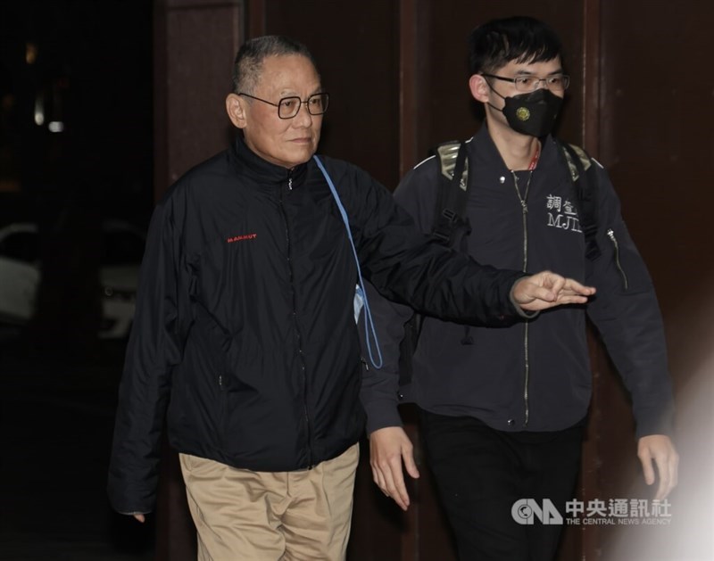 Chang Chun-chieh (left) is escorted by a law enforcenment officer. CNA file photo