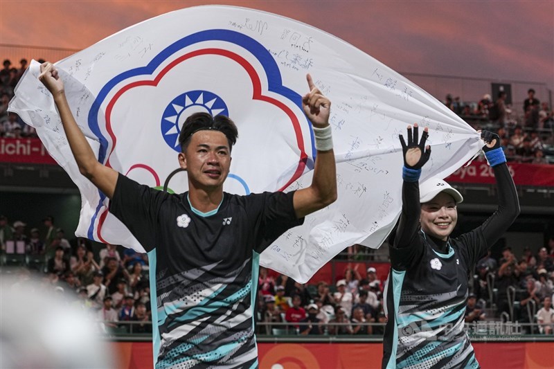 Yu Kai-wen (left) and Huang Shih-yuan (right) celebrate their victory by holding the Chinese Taipei Olympic flag as they walk around the venue after the match. CNA photo Sept. 21, 2026
