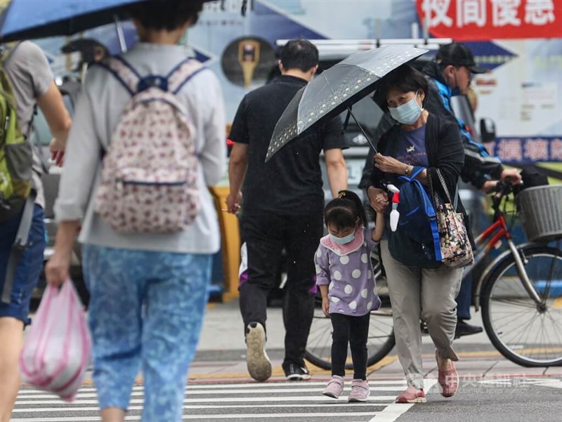 People cross a street amid wet weather in Taipei. CNA file photo