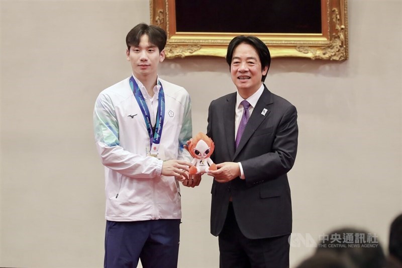 Taiwan President Lai Ching-te (right) meets with Taiwan's Asian Games gold medalist swimmer Wang Kuan-hung, who presents Lai with the mascot of the Nagoya Asian Games. CNA photo Oct. 6, 2026