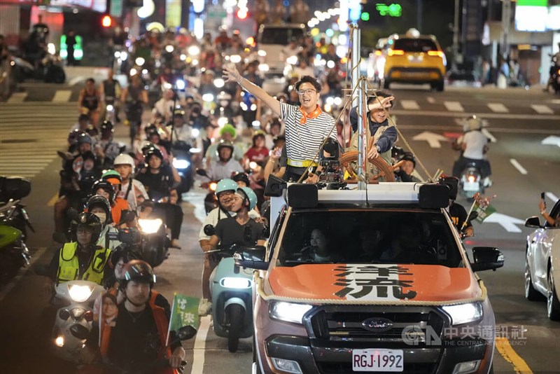 DPP Taipei mayoral candidate Puma Shen (standing on a campaign truck) waves to supporters during a campaign activity on Sunday. CNA photo Oct. 11, 2026