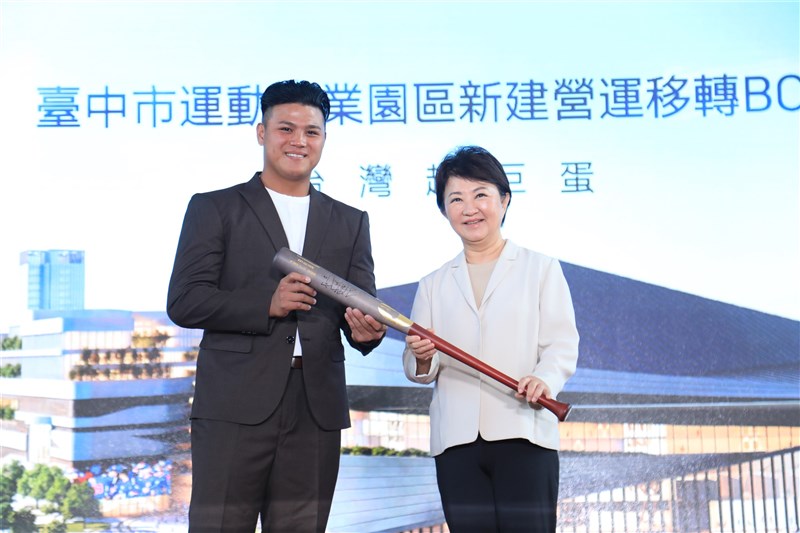 Taiwanese baseball player Lee Hao-yu (left) presents a signed bat to Taichung Mayor Lu Shiow-yen on Friday. Photo courtesy of the Taichung City Government